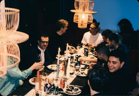 Kolleger langs et middagsbord med stearinlys