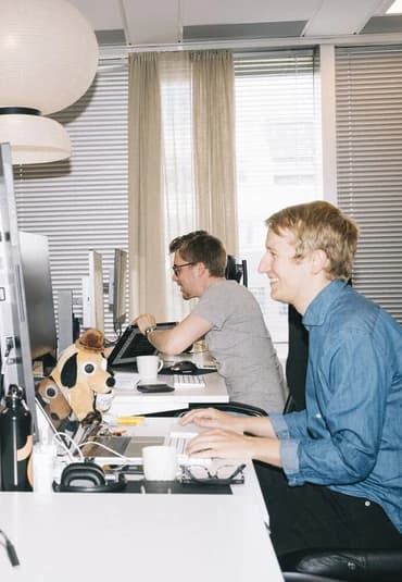 En kollega arbejder ved et skrivebord i et lyst kontor