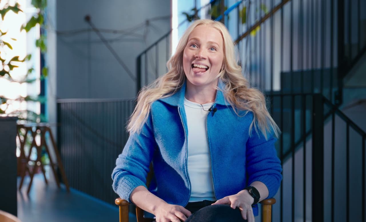 Oona in a blue jacket, mid-interview about switching to CoCoach