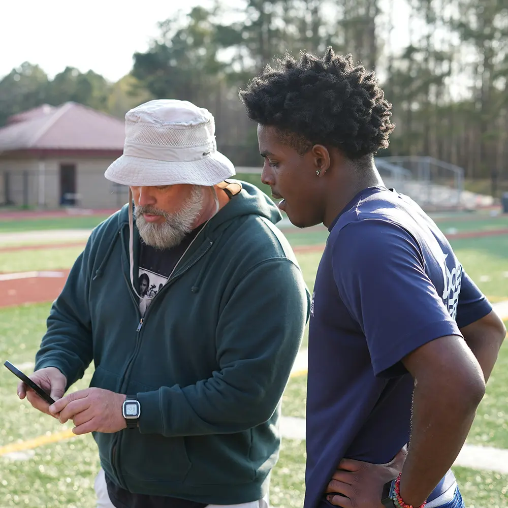 Coach showing workout tips to an athlete – real-life connection as a foundation for online following.