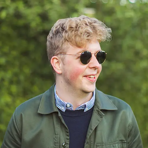 Frederik Fredslund Lassen, lead developer at CoCoach, smiling outdoors with sunglasses on – driving innovation and platform growth behind the scenes.